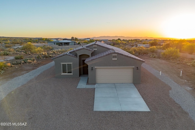 view of front of house with an attached garage, driveway, and stucco siding