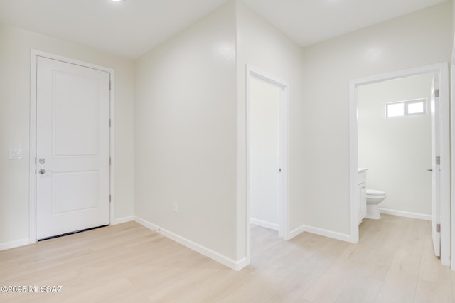 entrance foyer featuring light wood-type flooring and baseboards