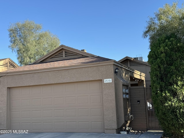 view of front of house with an attached garage, driveway, and stucco siding