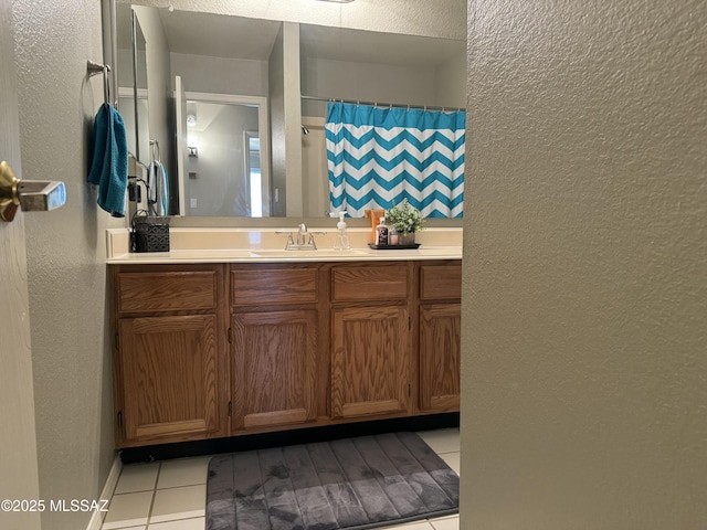 bathroom featuring a textured wall, tile patterned flooring, vanity, and a shower with curtain