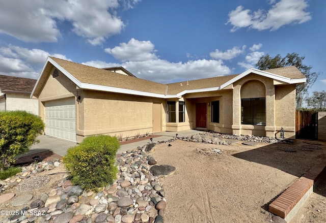 view of front facade featuring a garage, fence, stucco siding, and concrete driveway
