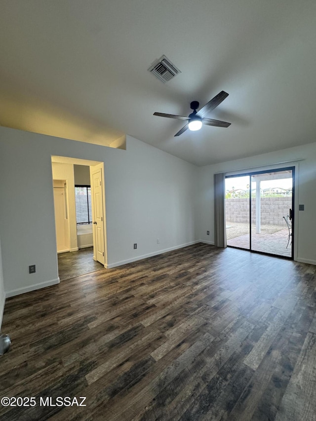unfurnished room featuring dark wood-style flooring, ceiling fan, visible vents, and baseboards