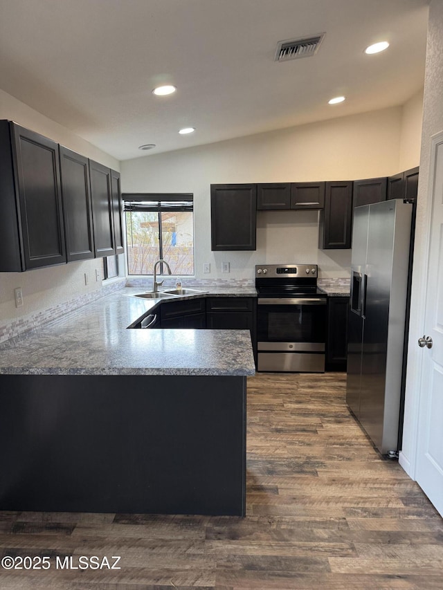 kitchen featuring visible vents, a sink, a peninsula, stainless steel appliances, and recessed lighting