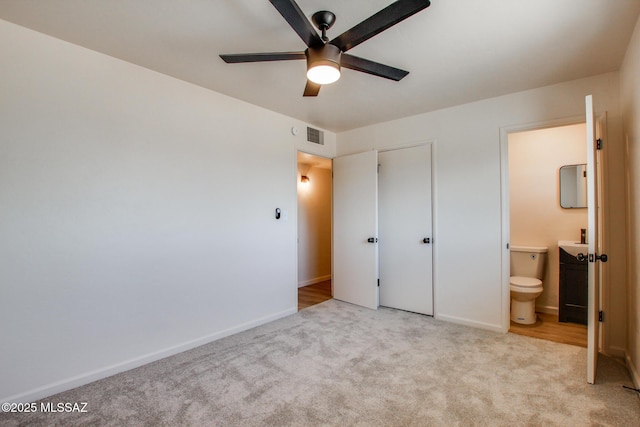 unfurnished bedroom featuring baseboards, carpet floors, connected bathroom, and visible vents