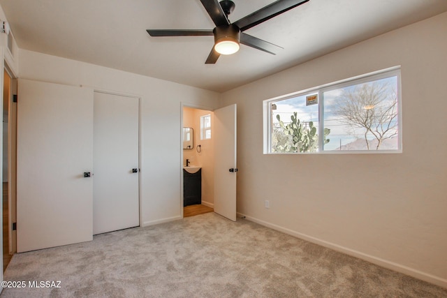 unfurnished bedroom featuring connected bathroom, baseboards, and carpet flooring