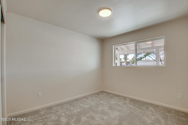 empty room featuring carpet flooring and baseboards