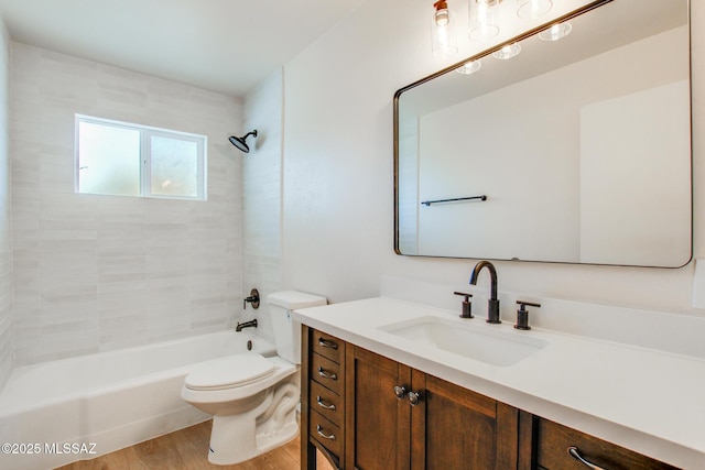 bathroom featuring toilet, vanity, shower / tub combination, and wood finished floors