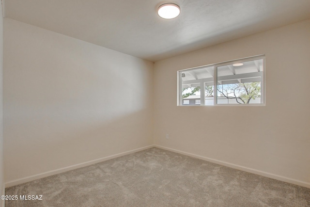 carpeted spare room with baseboards