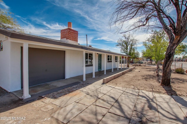 exterior space with a garage, fence, and a chimney