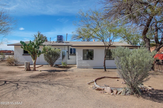 back of house with stucco siding and cooling unit