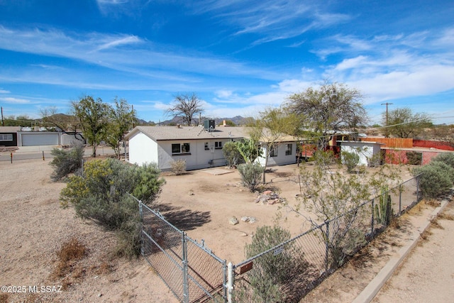 rear view of property featuring a gate and fence
