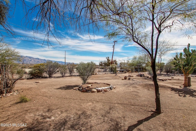 view of yard featuring fence and a mountain view