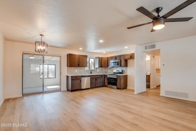 kitchen with visible vents, light countertops, backsplash, and stainless steel appliances