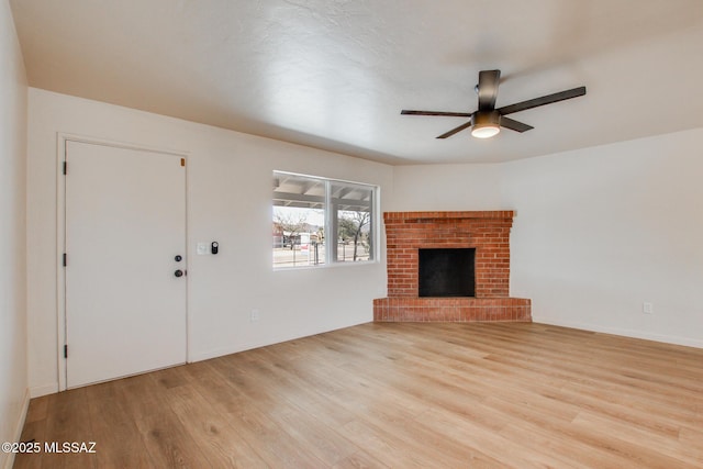 unfurnished living room with a ceiling fan, a fireplace, and wood finished floors