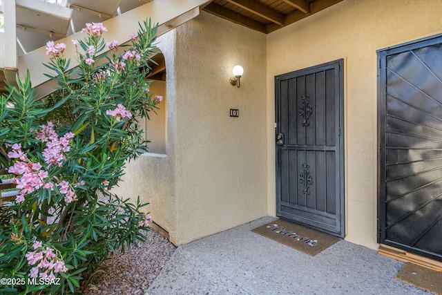 entrance to property featuring stucco siding