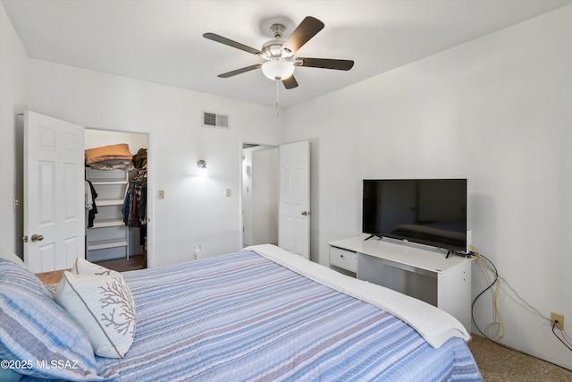 bedroom with carpet, a closet, a ceiling fan, visible vents, and a walk in closet
