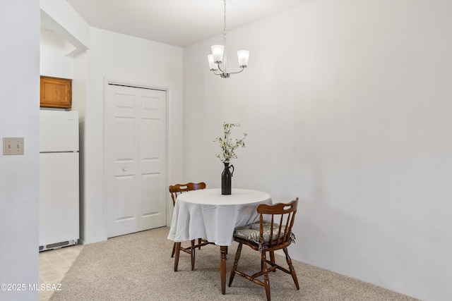 dining area with light colored carpet and a notable chandelier