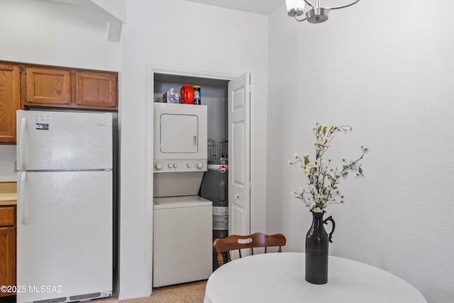 dining area with stacked washer and clothes dryer and an inviting chandelier