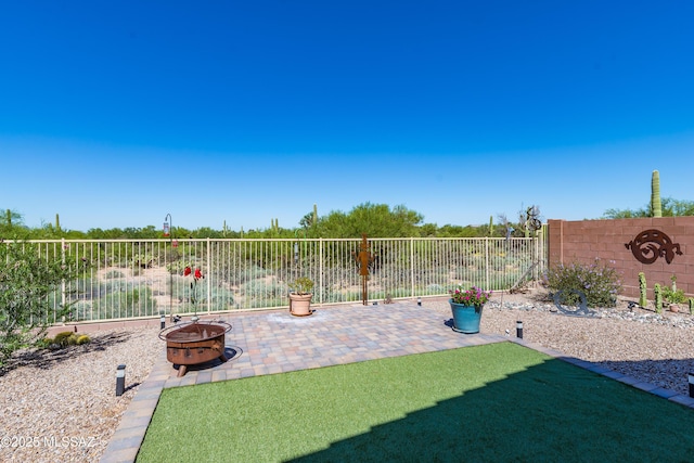 view of yard featuring a patio area, a fire pit, and fence