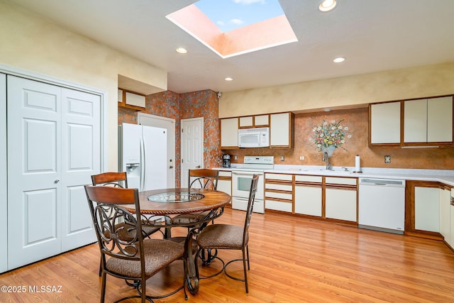 dining space featuring recessed lighting, light wood-style floors, and a skylight