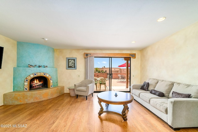 living room featuring a fireplace, wood finished floors, and recessed lighting