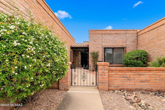 view of exterior entry featuring a gate and fence