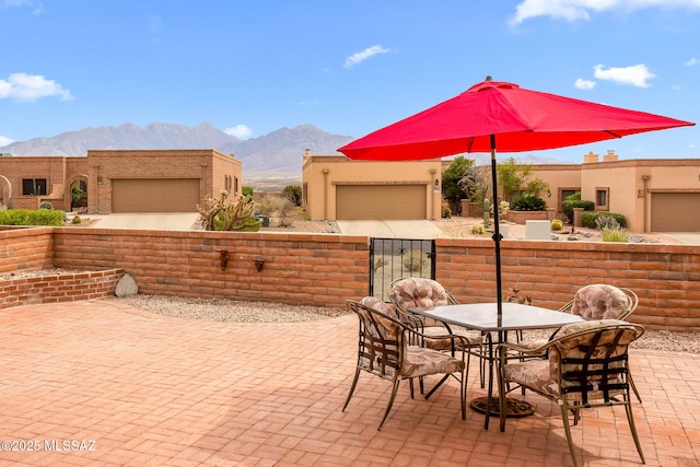 view of patio featuring a gate, a mountain view, outdoor dining area, and fence