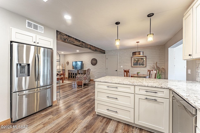 kitchen with white cabinetry, stainless steel fridge, visible vents, a peninsula, and wood finished floors