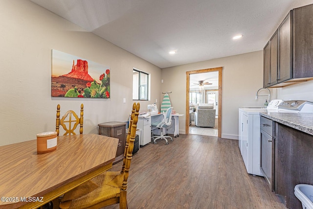 interior space featuring baseboards, a ceiling fan, dark wood-type flooring, dark brown cabinetry, and separate washer and dryer