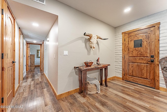 foyer featuring baseboards and wood finished floors