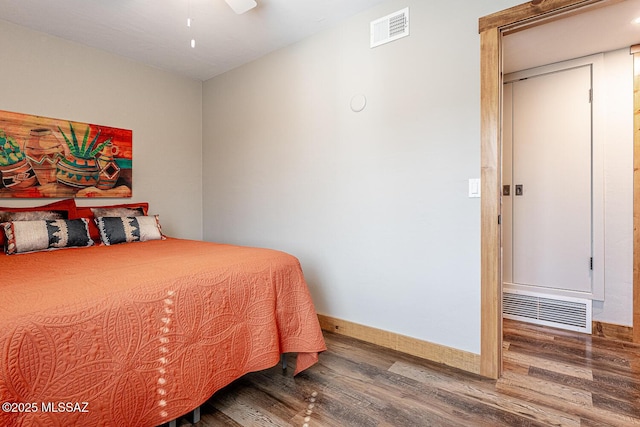bedroom with wood finished floors, baseboards, ceiling fan, and visible vents