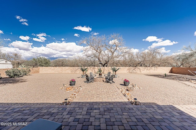view of yard featuring a patio, a fire pit, and a fenced backyard