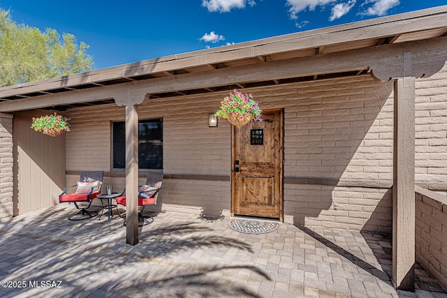 view of exterior entry with a patio