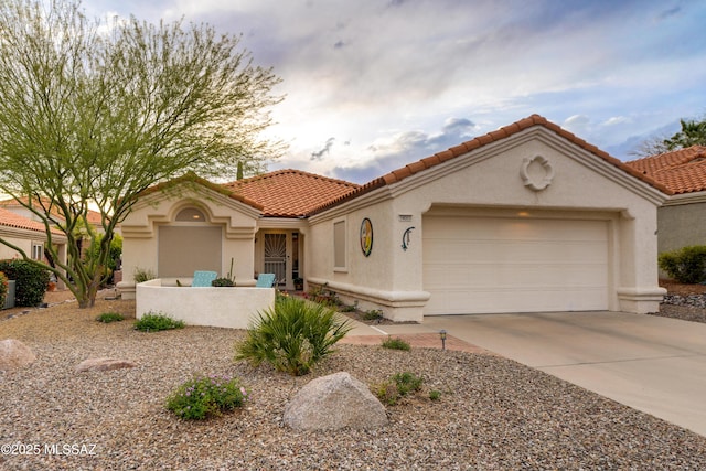 mediterranean / spanish-style home featuring a garage, driveway, stucco siding, and a tile roof