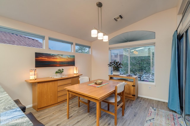 dining area featuring light wood-type flooring, baseboards, lofted ceiling, and visible vents