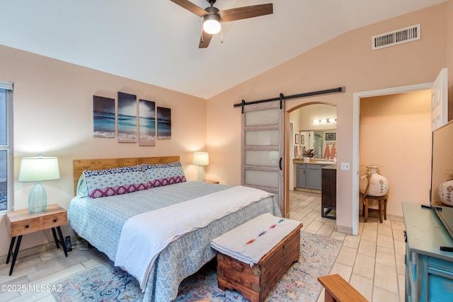 bedroom with visible vents, ensuite bathroom, light tile patterned floors, arched walkways, and lofted ceiling