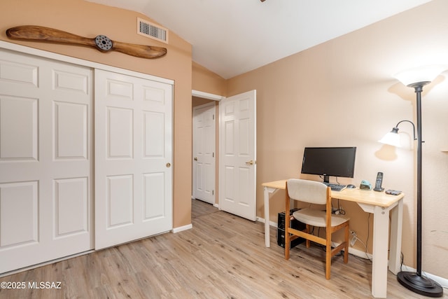 office area featuring visible vents, baseboards, wood finished floors, and lofted ceiling