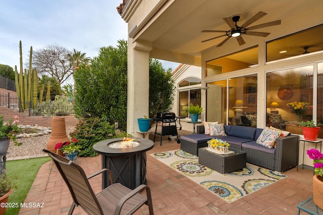 view of patio featuring an outdoor living space with a fire pit, fence, and a ceiling fan