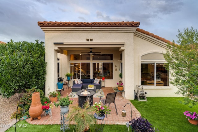 rear view of property featuring a patio area, stucco siding, a tile roof, and a lawn