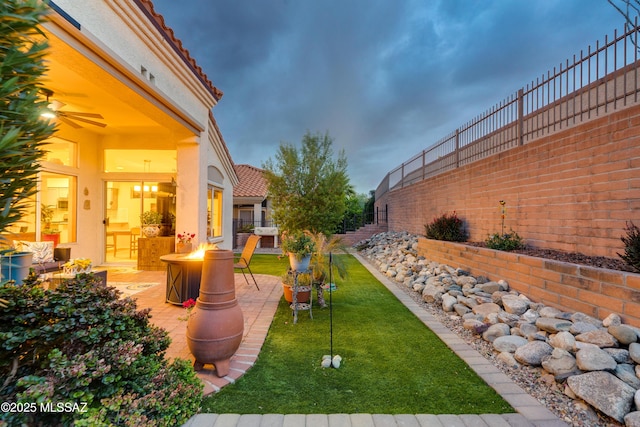 view of yard with a patio area, fence, and an outdoor fire pit
