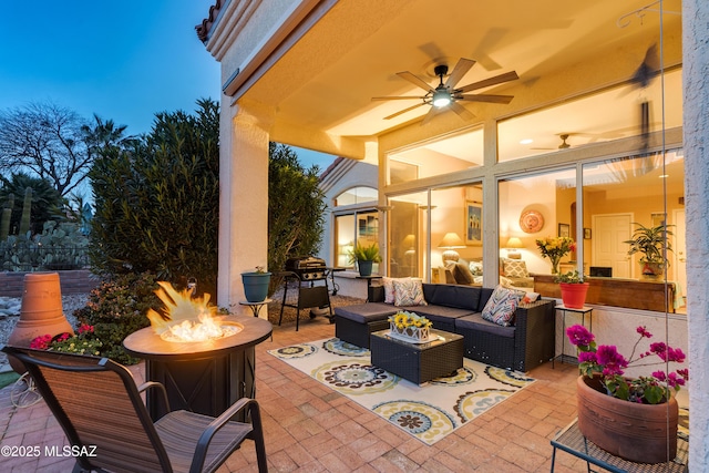 view of patio / terrace with an outdoor living space with a fire pit and ceiling fan