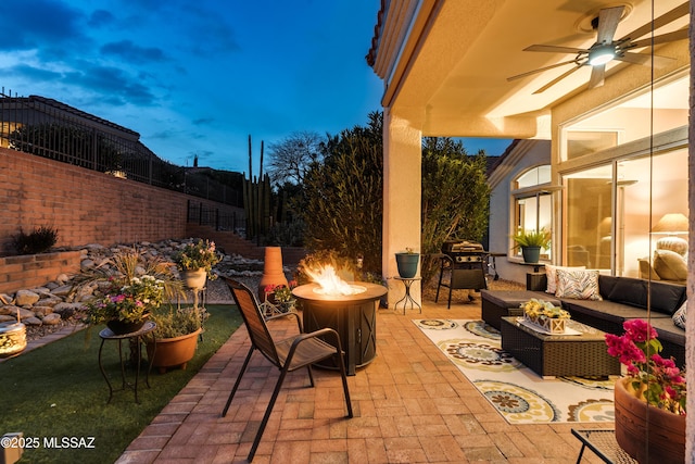 view of patio with an outdoor living space with a fire pit and ceiling fan