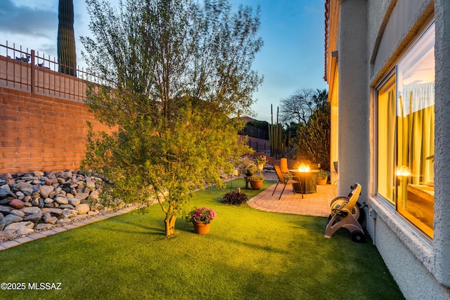 view of yard featuring a fire pit, a patio, and fence