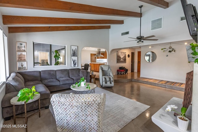 living room featuring arched walkways, ceiling fan, and concrete flooring