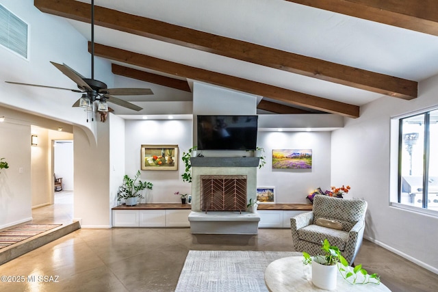 living room with a fireplace with raised hearth, ceiling fan, baseboards, arched walkways, and concrete flooring