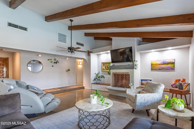 living area featuring a fireplace with raised hearth, wood finished floors, arched walkways, baseboards, and a ceiling fan
