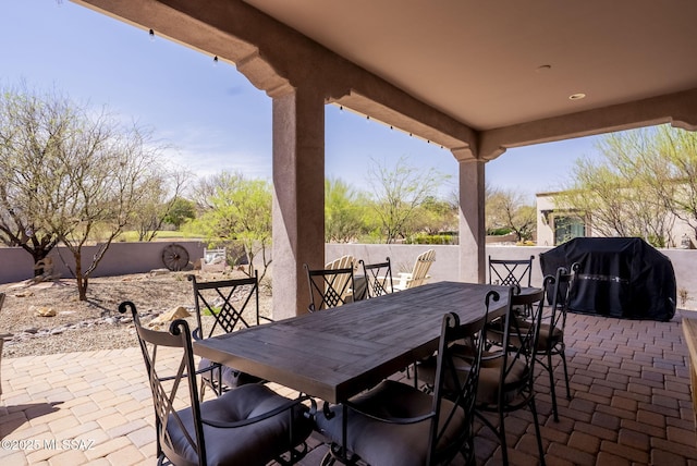 view of patio featuring outdoor dining area, a fenced backyard, and grilling area