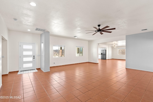 unfurnished living room featuring light tile patterned flooring, a textured ceiling, visible vents, and ceiling fan with notable chandelier