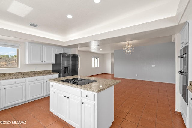 kitchen featuring black electric cooktop, visible vents, recessed lighting, stainless steel fridge with ice dispenser, and a center island