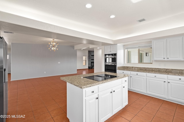 kitchen featuring stainless steel double oven, black electric stovetop, light tile patterned floors, visible vents, and an inviting chandelier